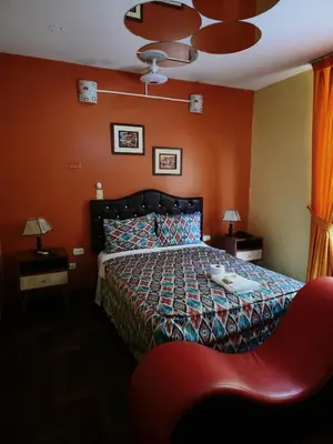 a bedroom with a bed and a red wall at Sahara Hotel in Lima