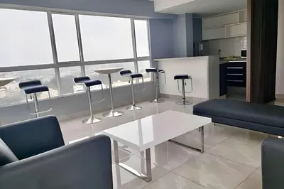 a living room with chairs and a table and a counter at Modern Apartment between Miraflores & Surquillo in Lima