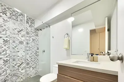 a white bathroom with a sink and a shower at Torre Platinium in Lima