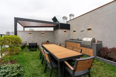 an outdoor patio with a wooden table and chairs at Celestra by Geko in Lima