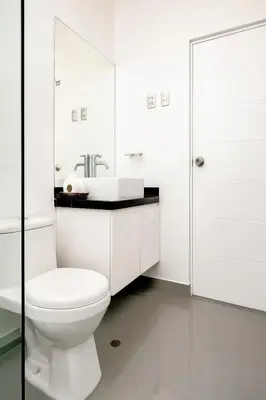 a white bathroom with a toilet and a sink at Mystic Paracas Hotel & Glampings in Paracas