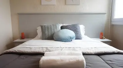 a bed with two blankets and pillows on it at Cozy 2BR, Prime Barranco, 7th Flr in Lima