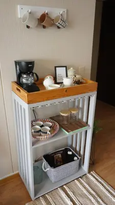 a small white cabinet with cups and dishes on it at Cozy 2BR, Prime Barranco, 7th Flr in Lima