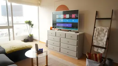 a living room with a tv on top of a dresser at Cozy 2BR, Prime Barranco, 7th Flr in Lima