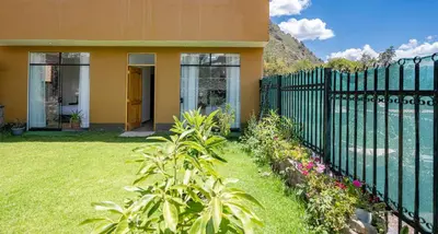 a fence in front of a house with a yard at Rural Retreat with Charming Patio 2 Bedrooms in Urubamba