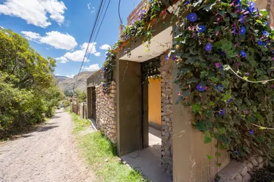 a house with flowers on the side of a road at Rural Retreat with Charming Patio 2 Bedrooms in Urubamba
