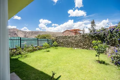 a garden with a stone fence and flowers at Rural Retreat with Charming Patio 2 Bedrooms in Urubamba