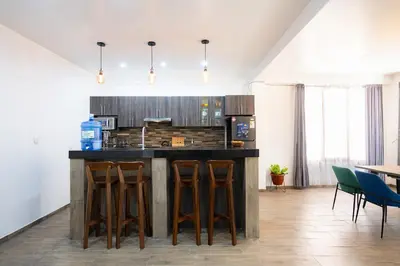 a kitchen with a island with bar stools at Rural Retreat with Charming Patio 2 Bedrooms in Urubamba