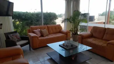 a living room with two couches and a coffee table at Casa amplia con jardín frente al mar in Lurín
