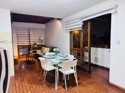 a table and chairs in a living room with a table at Monterrico Polo Apart 4 - Frente Embajada USA in Lima