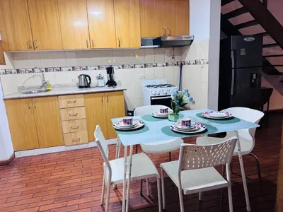 a kitchen with a blue table and chairs in a room at Monterrico Polo Apart 4 - Frente Embajada USA in Lima