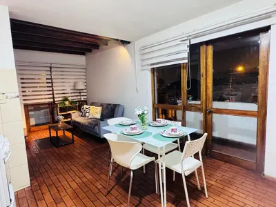a living room with a table and chairs and a couch at Monterrico Polo Apart 4 - Frente Embajada USA in Lima