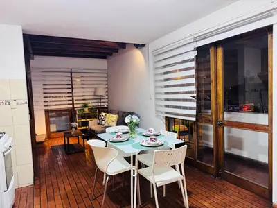 a living room with a table and chairs and a couch at Monterrico Polo Apart 4 - Frente Embajada USA in Lima