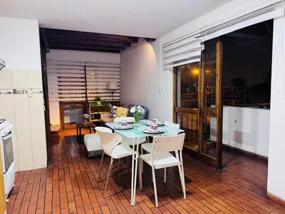 a room with a table and chairs and a kitchen at Monterrico Polo Apart 4 - Frente Embajada USA in Lima