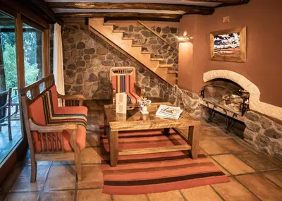 a living room with a table and chairs and a staircase at Dreamy cabins in Urubamba