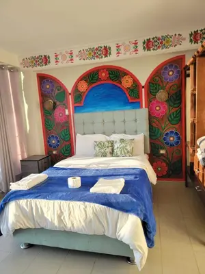 a bedroom with a large bed with a painting on the wall at Hotel Sucre in Quinua