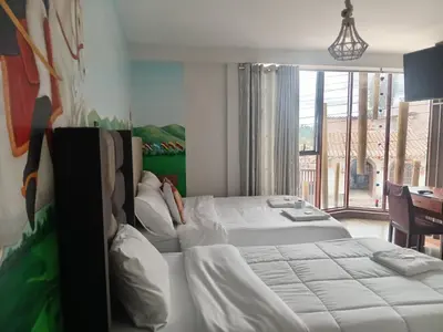 a bedroom with two beds and a large window at Hotel Sucre in Quinua