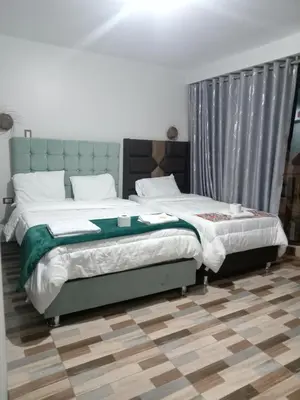 a bedroom with a large bed with a gray headboard at Hotel Sucre in Quinua