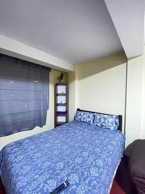 a bedroom with a bed with a blue comforter at Habitacion amplia cerca al aeropuerto in Lima
