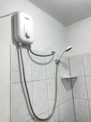 a shower with a hose attached to a wall at Habitacion amplia cerca al aeropuerto in Lima