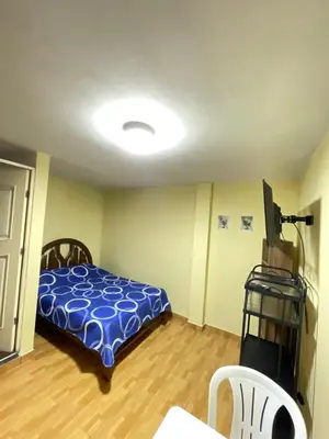 a bedroom with a bed and a television in it at Habitacion privada cerca al aeropuerto in Lima