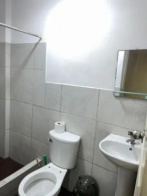 a bathroom with a white toilet and a sink at Habitacion privada cerca al aeropuerto in Lima