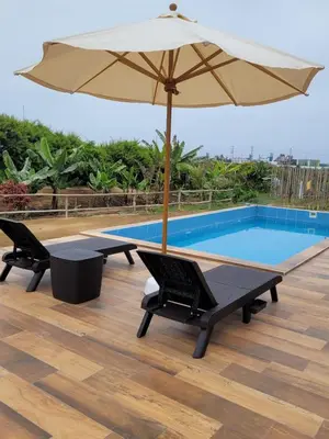 a pool with two chairs and an umbrella at Casa de Campo La Martina con piscina y parrilla in Tambo de Mora