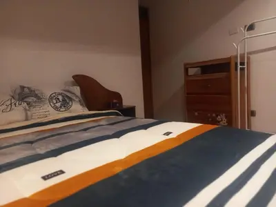 a bedroom with a bed and a wooden dresser at Habitación en Cusco in Cusco