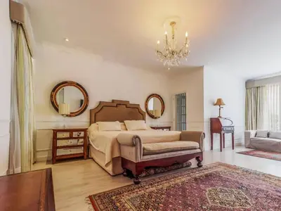 a bedroom with a bed and a couch and mirrors at Apartment in the historic central of the city in Cusco