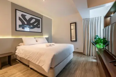 a bedroom with a large white bed and a window at Lumiere 1BR by Geko in Lima