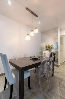 a dining room with a wooden table and chairs at Lumiere 1BR by Geko in Lima