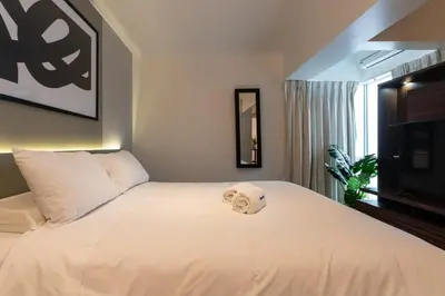 a bedroom with a white bed with a towel on it at Lumiere 1BR by Geko in Lima