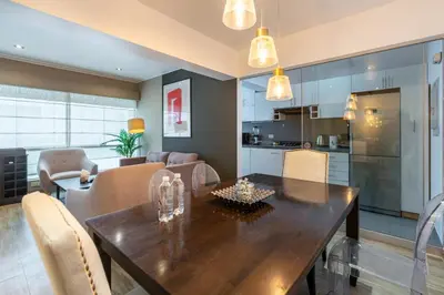 a kitchen and dining room with a wooden table and chairs at Lumiere 1BR by Geko in Lima
