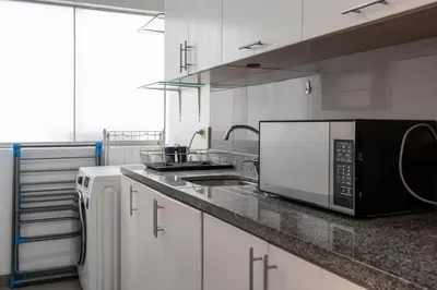 a kitchen with a microwave oven and a sink at Lumiere 1BR by Geko in Lima