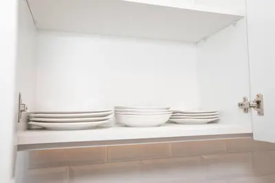 a shelf with plates and bowls on it in a kitchen at BSR Modern Spacious New Flat in Miraflores w/ Pool in Lima