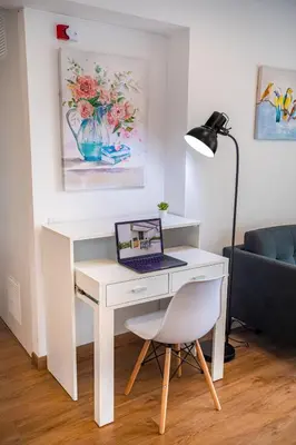 a white desk with a laptop on it next to a couch at BSR Modern Spacious New Flat in Miraflores w/ Pool in Lima