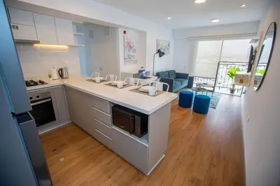a kitchen with a counter and a living room at BSR Modern Spacious New Flat in Miraflores w/ Pool in Lima