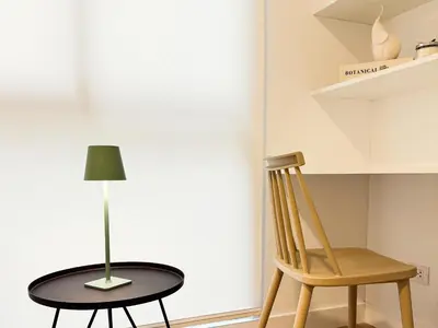a table with a lamp and a chair at New 2D gym-grill Miraflores 1 block Malecón in Lima