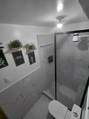 a bathroom with a shower and a toilet with cards at Moderno Depa Céntrico en Abancay in Abancay