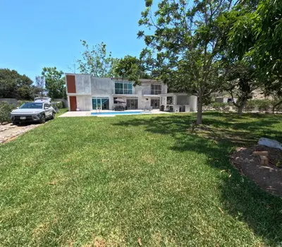 a house with a lawn in front of it at Casa campo las Pecanas Huaral