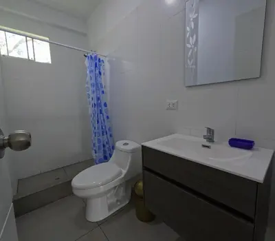 a white bathroom with a toilet and a sink at Casa campo las Pecanas Huaral