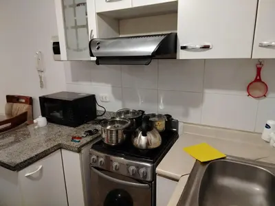 a kitchen with a stove with pots and pans on it at Acogedor Departamento entero en Chorrillos in Lima