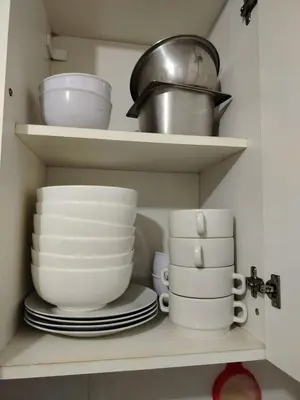 a shelf with plates and bowls and other dishes in a kitchen at Acogedor Departamento entero en Chorrillos in Lima