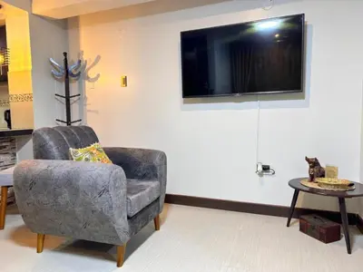 a living room with a chair and a tv on a wall at Apartamento Lucky House Cusco in Cusco