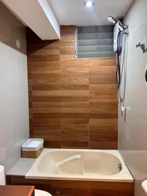 a bathroom with a white tub and wooden walls at Apartamento Lucky House Cusco in Cusco