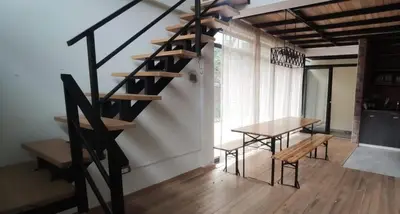 a staircase in a room with a table and a bench at Casa familiar en Oxapampa hasta 5 personas con cochera in Oxapampa