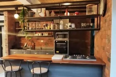 a kitchen with a bar with two chairs and a counter at Casa familiar en Oxapampa hasta 5 personas con cochera in Oxapampa