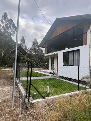 a fence in front of a house with a yard at Casa familiar en Oxapampa hasta 5 personas con cochera in Oxapampa