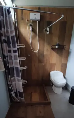 a bathroom with a shower with a toilet and a shower curtain at Casa familiar en Oxapampa hasta 5 personas con cochera in Oxapampa
