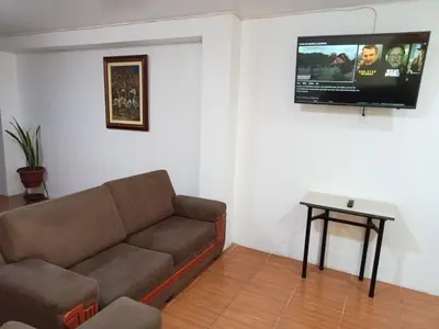 a living room with a couch and a flat screen tv at Departamento 1dormitorio 3A in Lima